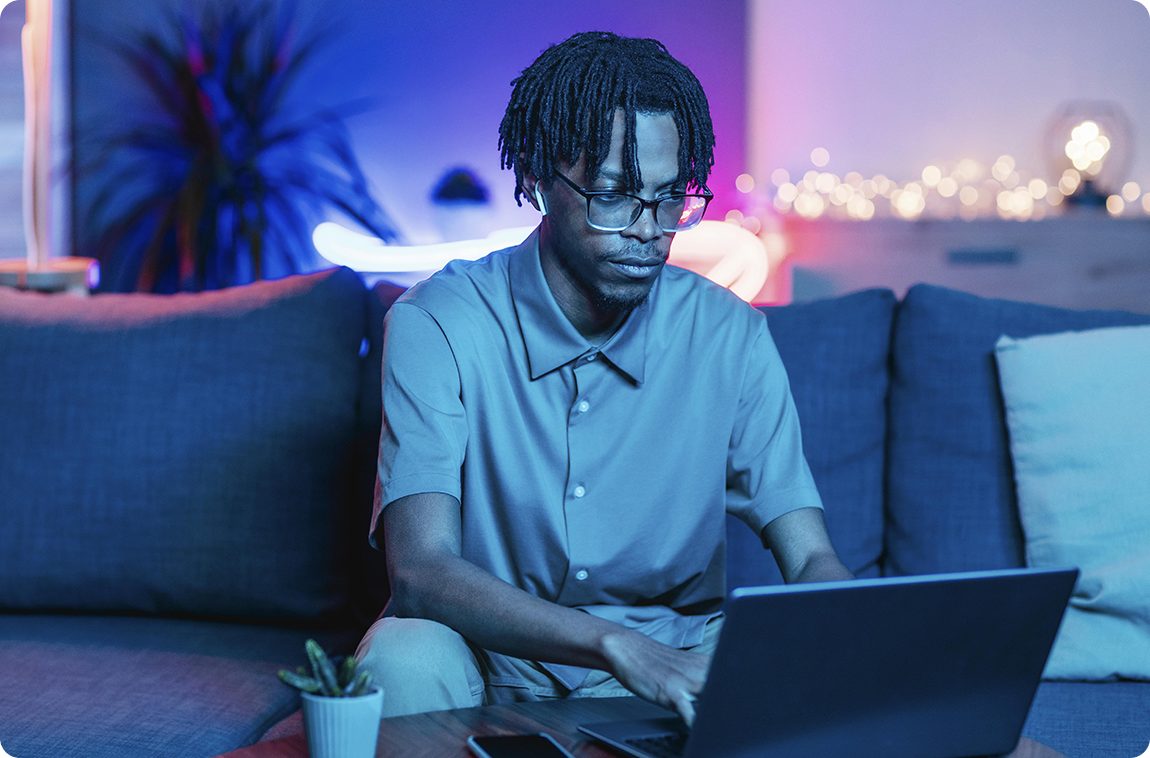 Homem usando notebook no sofá de casa